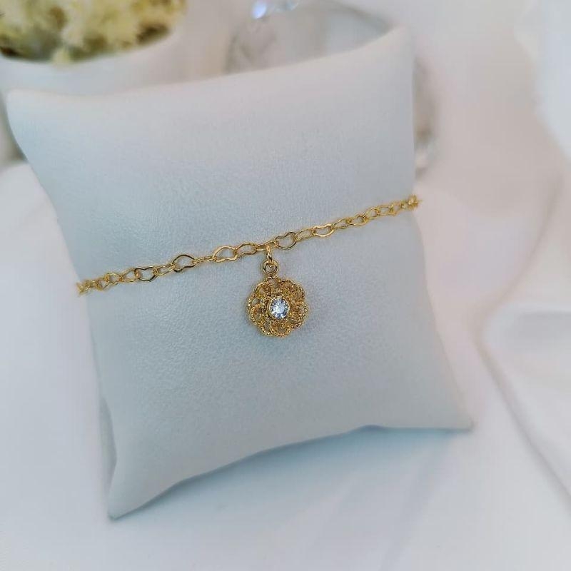 PULSEIRA COM PIGENTE DE FLOR VAZADA COM ZIRCONIA CENTRAL