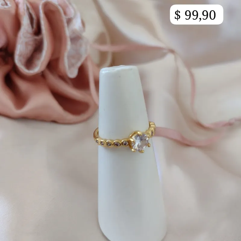 ANEL COM PEDRAS SOLITARIA E DETALHES OVAL NA LATERAL