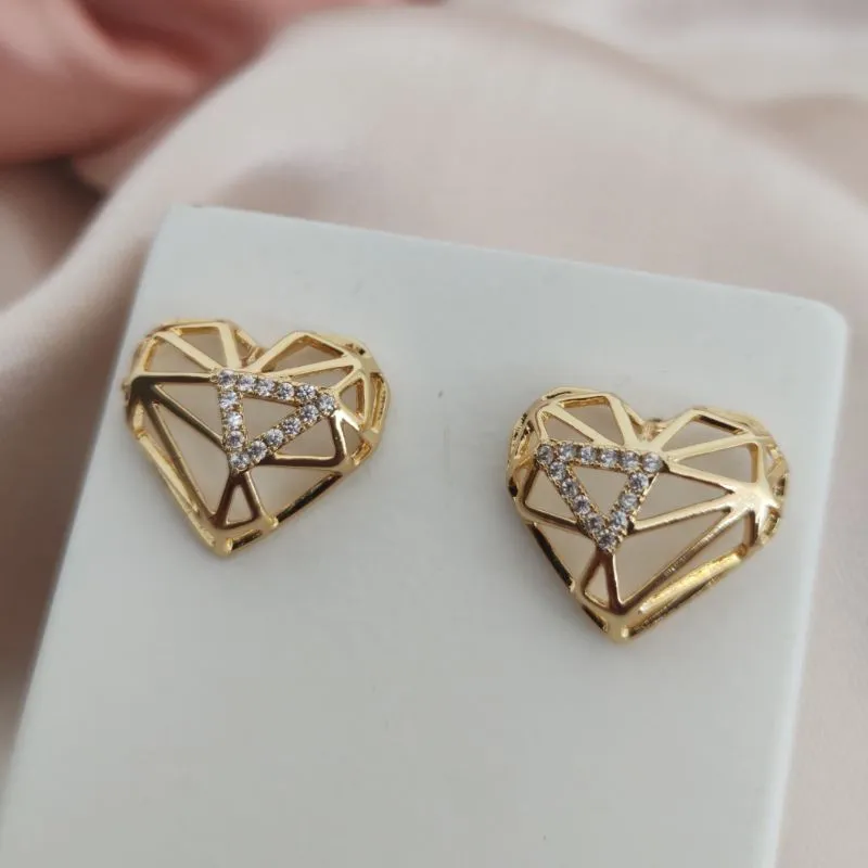 BRINCO DE CORAÇÃO COM FORMAS VAZADAS E TRIAMGULO CRAVEJADO EM MICRO ZIRCONIA BRINCO DE CORAÇÃO COM FORMAS VAZADAS E TRIAMGULO CRAVEJADO EM MICRO ZIRCONIA