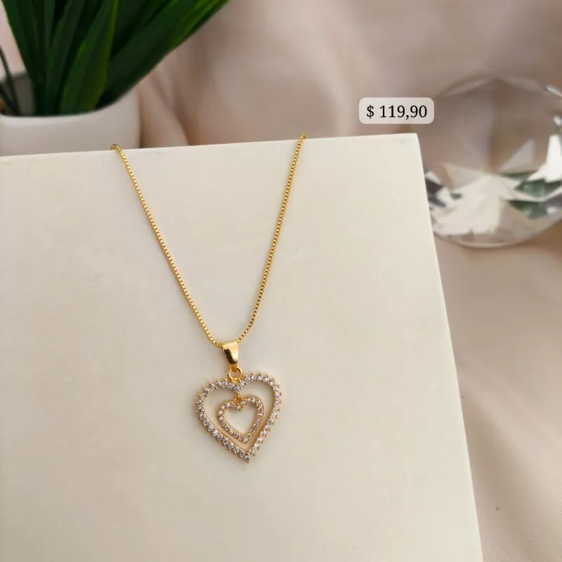 COLAR COM PINGENTE DE 2 CORAÇÃES UM DENTRO DO OUTRO SOLTO VAZADO E CRAVEJADO SO AO REDOR COLAR COM PINGENTE DE 2 CORAÇÃES UM DENTRO DO OUTRO SOLTO VAZADO E CRAVEJADO SO AO REDOR
