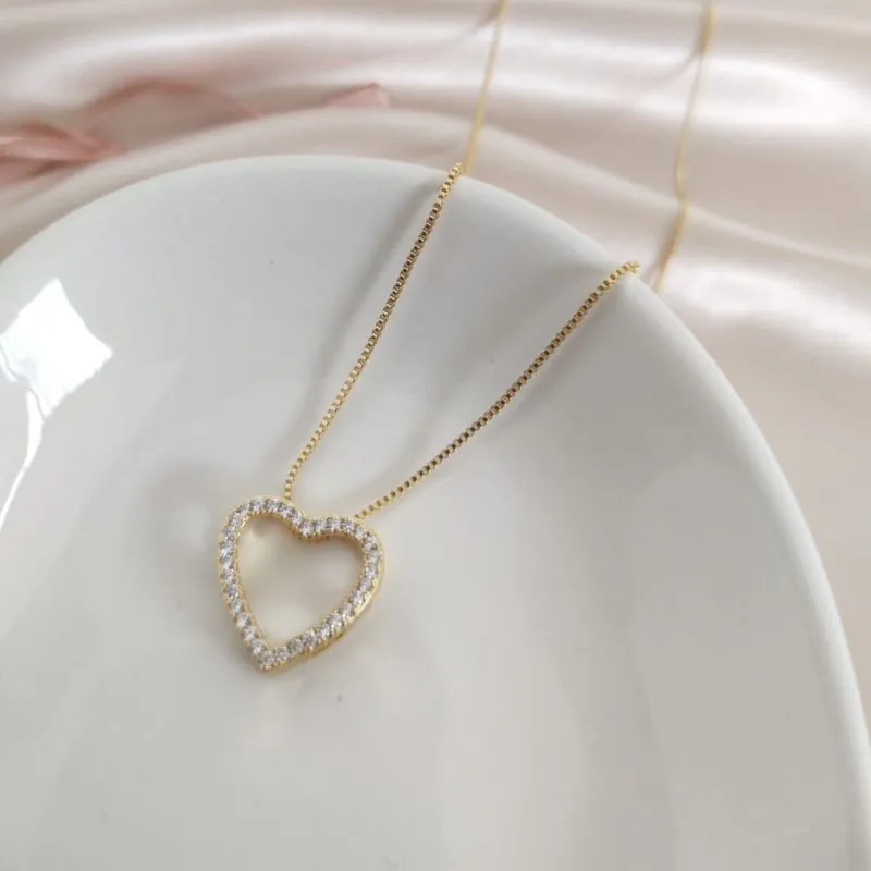 COLAR COM PINGENTE DE CORAÇÃO VAZADO E CRAVEJADO EM MICRO ZIRCONIA COLAR COM PINGENTE DE CORAÇÃO VAZADO E CRAVEJADO EM MICRO ZIRCONIA