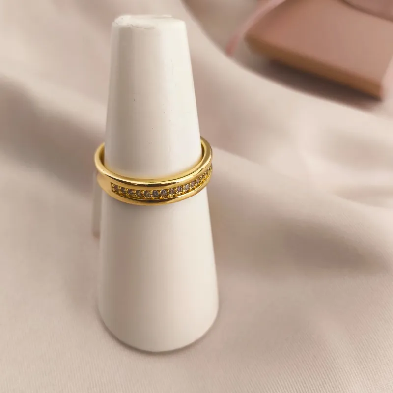 ANEL COM LATERAIS LISAS E NO MEIO CRAVEJADO EM MICRO ZIRCONIA ANEL COM LATERAIS LISAS E NO MEIO CRAVEJADO EM MICRO ZIRCONIA