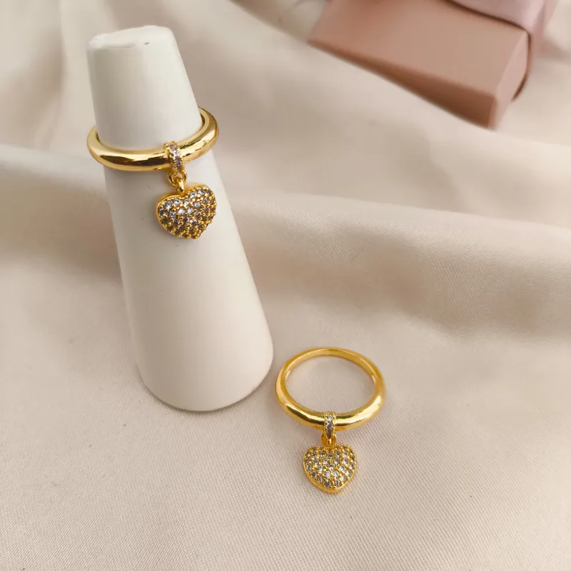 ANEL LISO COM CORAÇÃO PENDURADO CRAVEJADO EM MICRO ZIRCONIA ANEL LISO COM CORAÇÃO PENDURADO CRAVEJADO EM MICRO ZIRCONIA