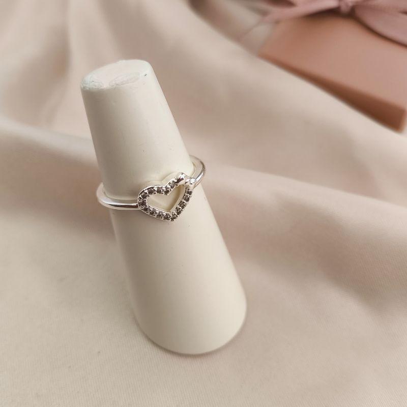 ANEL COM CORAÇÃO VAZADO CRAVEJADO EM MICRO ZIRCONIA COM LAÇO LISO NA PARTE DE CIMA