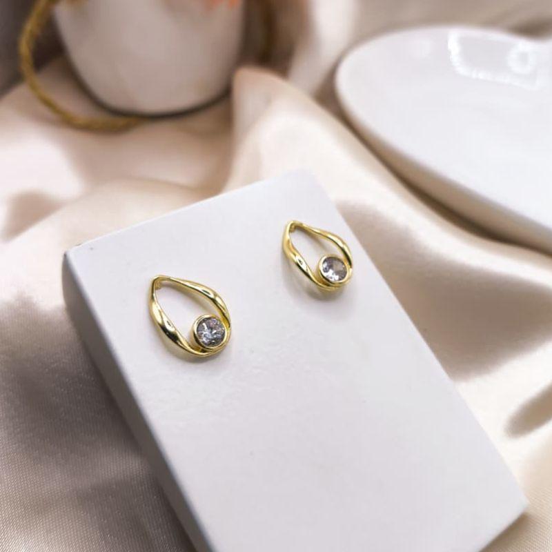 BRINCO COM FORMA DISTORCIDA COM PEDRA DE ZIRCONIA NA PONTA SUPERIOR