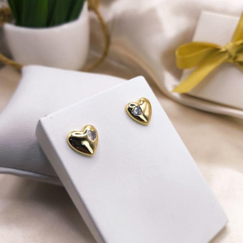 BRINCO CORAÇÃO LISO COM UMA PEDRA DE ZIRCONIA DO LADO EM FORMA DE CORAÇÃO