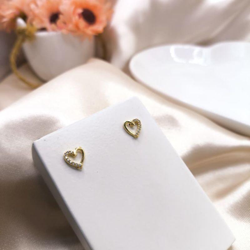 BRINCO CORAÇÃO VAZADO METADE LISO E METADE CRAVEJADO EM MICRO ZIRCONIA