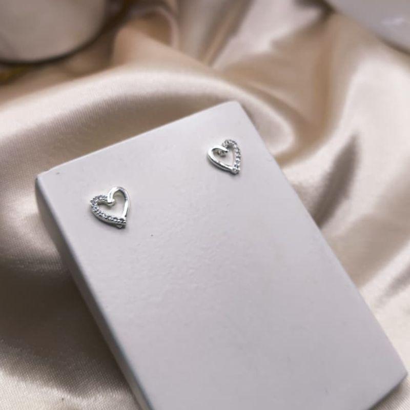 BRINCO CORAÇÃO VAZADO METADE LISO E METADE CRAVEJADO EM MICRO ZIRCONIA