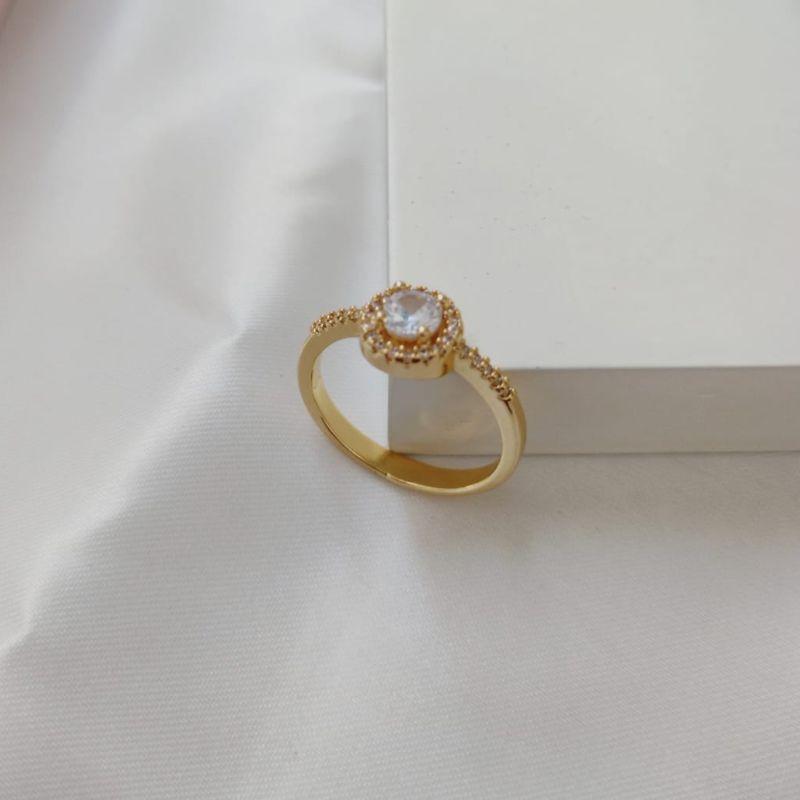 ANEL COM PEDRA REDONDA E CRAVEJADO EM MICRO ZIRCONIA AO REDOR