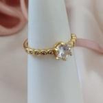 ANEL COM PEDRAS SOLITARIA E DETALHES OVAL NA LATERAL