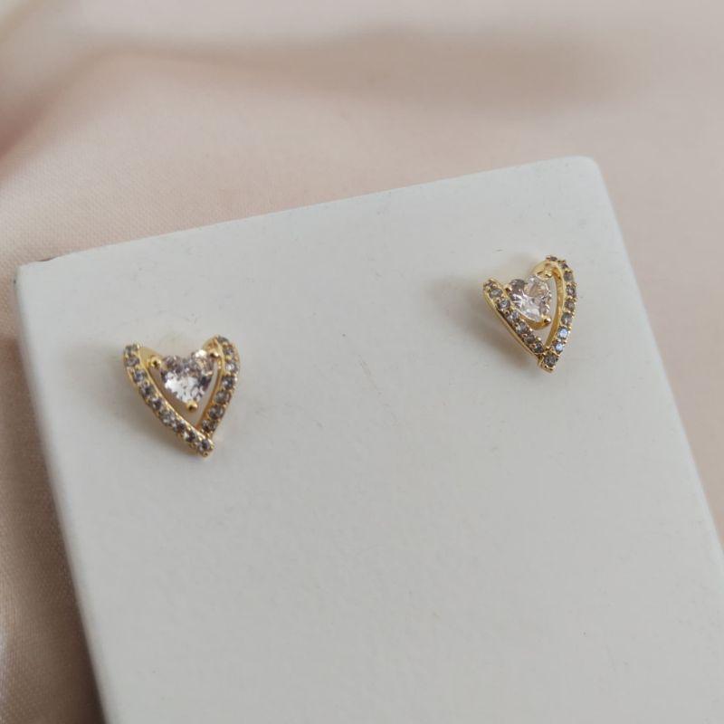 BRINCO DE CORAÇÃO TORTO CRAVEJADO EM MICRO ZIRCONIA E PEDRA CENTRAL DE ZIRCONIA