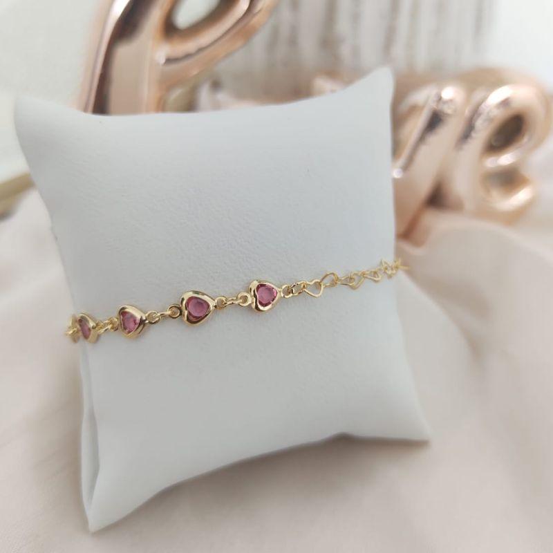 PULSEIRA INFANTIL MEIA CORAÇÃO ENTRELAÇADOS E MEIA PEDRAS DE CORAÇÕES ROSAS