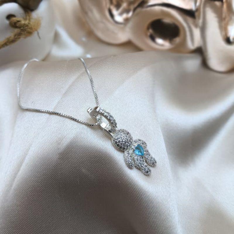 COLAR COM PINGENTE DE MENINO CRAVEJADO EM MICRO ZIRCONIA E CORAÇÃO AZUL NO MEIO