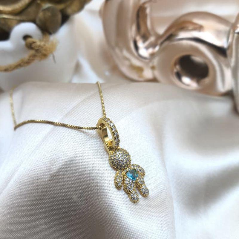 COLAR COM PINGENTE DE MENINO CRAVEJADO EM MICRO ZIRCONIA E CORAÇÃO AZUL NO MEIO
